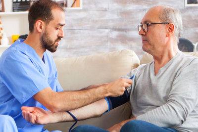 man checking the blood pressure of senior man